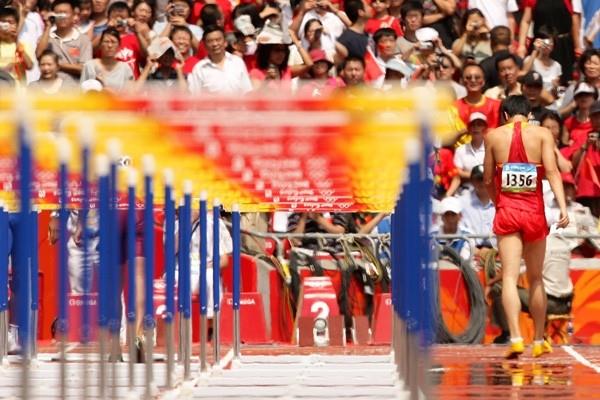 Liu Xiang walks off the track injured (Getty Images)