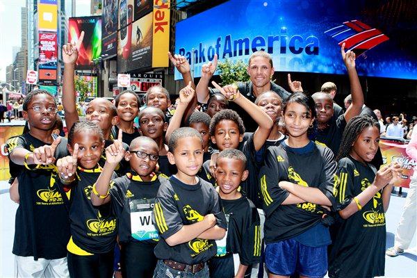 Dan O'Brien with young fans in New York City's Times Square during a '100 Kids - 100 metres - 100 years' relay event to mark the Centenary year of the IAAF, at which his inclusion into the IAAF Hall of Fame was announced. (Victah Sailer)