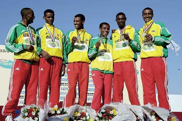 A smiling Bekele with short race gold medal team members (Getty Images)