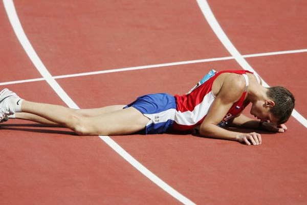 Denis Nizhegorodov of Russia collapses to the floor after taking silver in the 50km walk (Getty Images)
