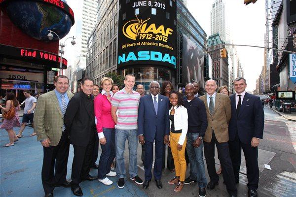 In front in NASDAQ headquarters in Times Square with the IAAF Centenary logo on the NASDAQ giant screen. First row from left: Mark Wetmore, Ian Stewart, Barbora Spotakova, Jesse Williams, Lamine Diack, Meseret Defar, Bernard Lagat, Steve Ovett, and Nick Davies (NASDAQ)