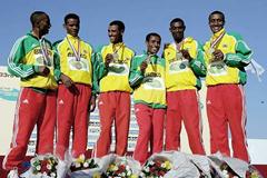 A smiling Bekele with short race gold medal team members (Getty Images)