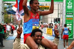 Zersenay Tadese celebrates with an Eritrean supporter after winning the IAAF/EDF Energy World Half Marathon Championships in Birmingham (Getty Images)