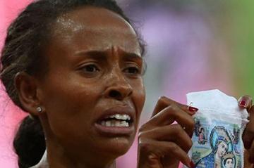Meseret Defar of Ethiopia holds up a picture as she won the gold medal in the Women's 5000m Final on Day 14 of the London 2012 Olympic Games on 10 August 2012 (Getty Images)